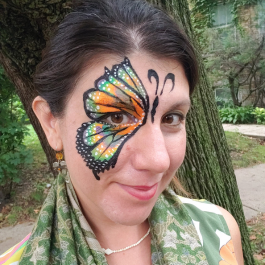 Valerie with butterfly wing face paint over her right eye