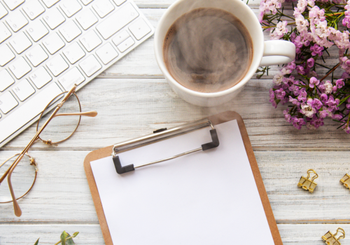 Resources image - flat lay with keyboard, clipboard, coffee, and flowers