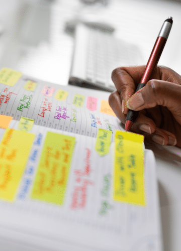 woman's hand writing in planner